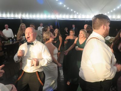 Wedding DJ services Syracuse getting guests to sing along on the dance floor