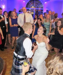 Wedding DJ services Syracuse filling a dance floor to surround the bride and groom in their big moment