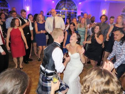 Wedding DJ services Syracuse filling a dance floor to surround the bride and groom in their big moment