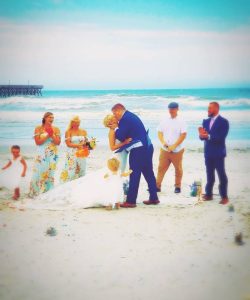 Wedding DJ services Syracuse serving as officiant to a couple getting married on a South Carolina beach